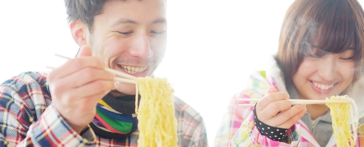 美味しそうにラーメンを食べる男女