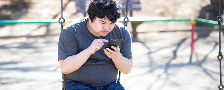 スマホをいじる男性の画像